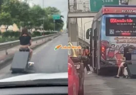 f4 wanita naik bagasi beroda atas jalan raya di Thailand